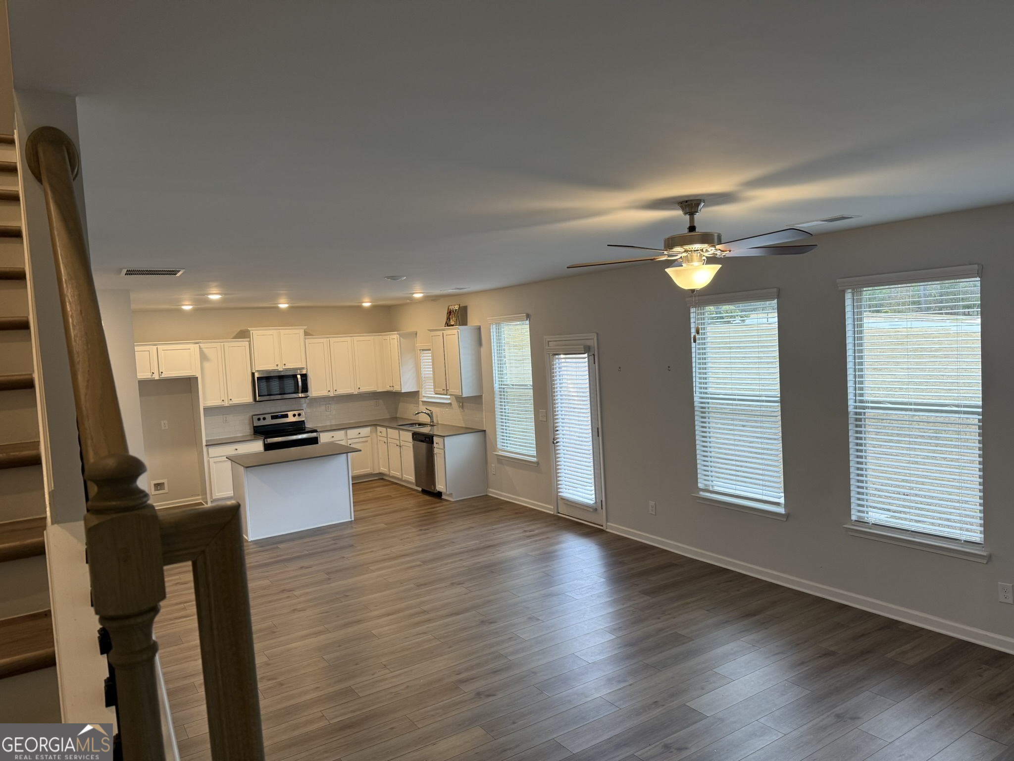 417 Sawmill Trace Hampton, GA 30228 - Photo 15 of 27 a living room with couches and kitchen view with wooden floor
