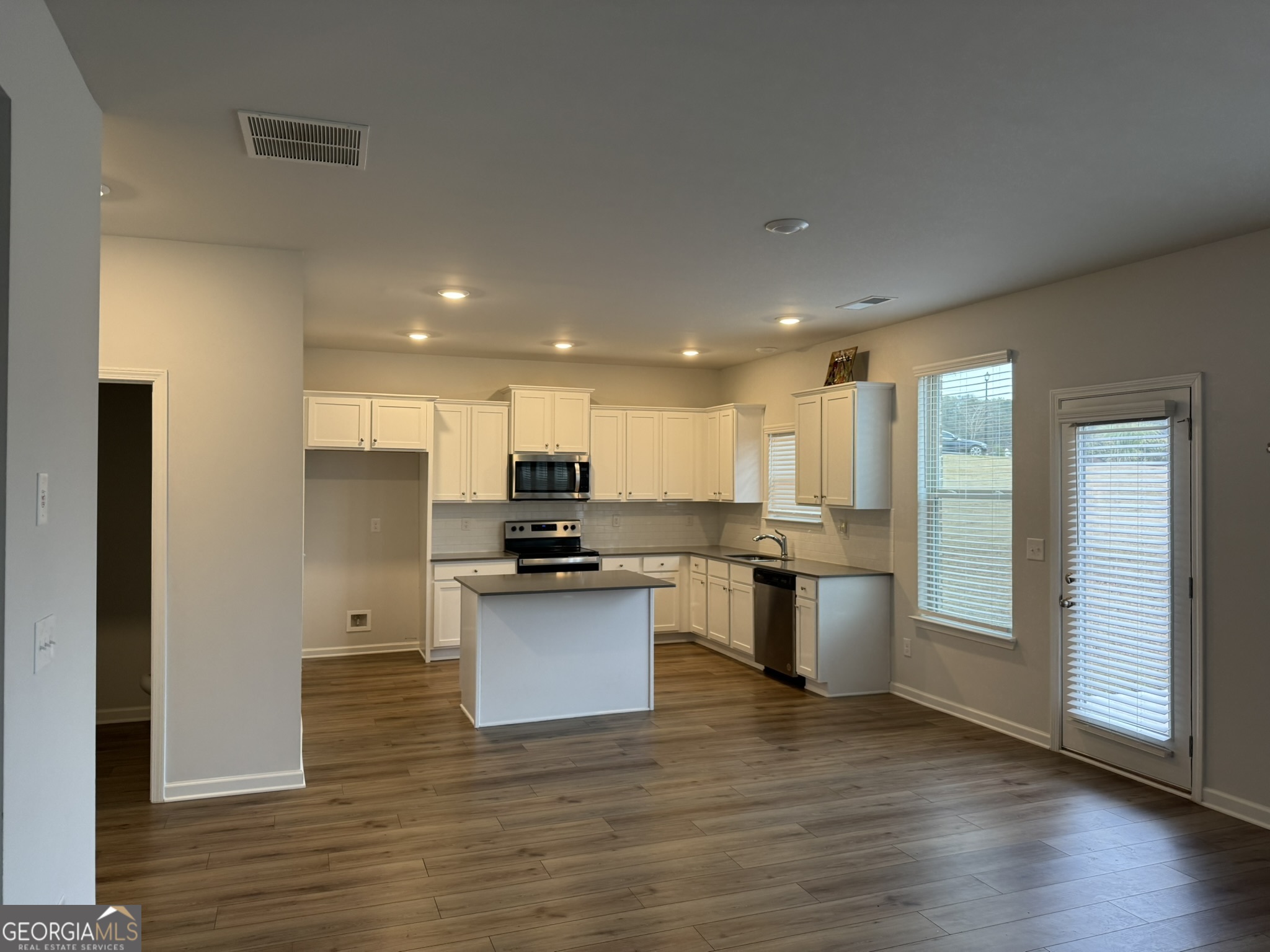 417 Sawmill Trace Hampton, GA 30228 - Photo 5 of 27 a kitchen with stainless steel appliances kitchen island granite countertop a stove a sink and a refrigerator