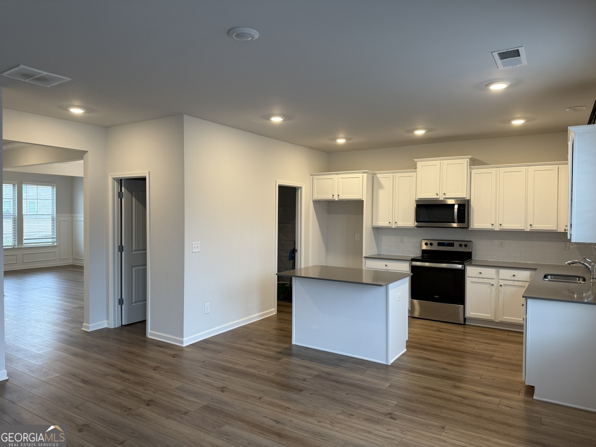 417 Sawmill Trace Hampton, GA 30228 - Photo 7 of 27 a kitchen with stainless steel appliances kitchen island granite countertop a stove a sink and a refrigerator