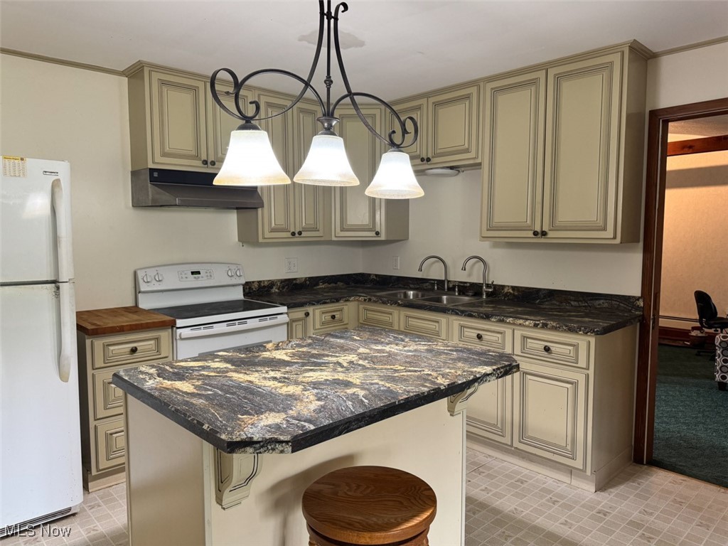 16510 Mock Road Berlin Center, OH 44401 - Photo 12 of 29 Kitchen featuring white appliances, under cabinet range hood, cream cabinets, a kitchen island, and hanging light fixtures