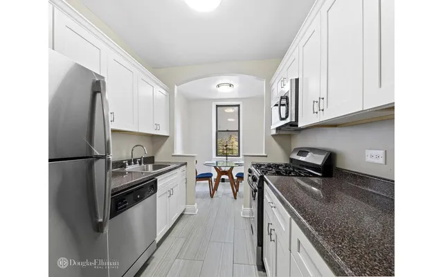 a room with kitchen island a large window and a chandelier