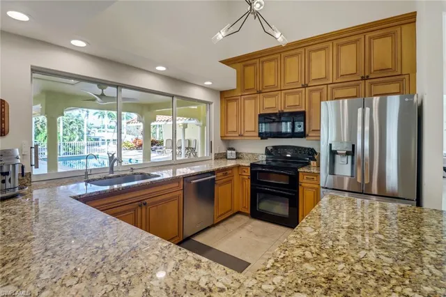 a kitchen with stainless steel appliances granite countertop a refrigerator stove top oven and sink