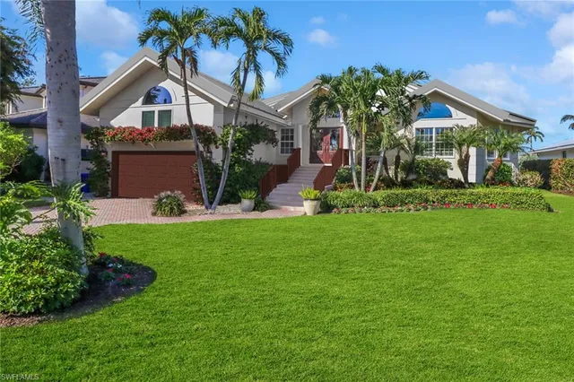 front view of house with a yard and potted plants