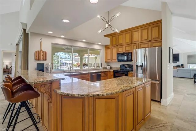a kitchen with stainless steel appliances granite countertop a stove refrigerator and a sink