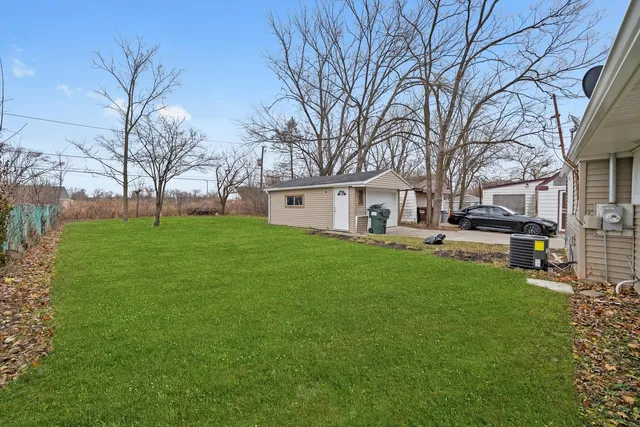 a white house that has a tree in front of a house