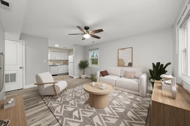 a living room with furniture and view of kitchen