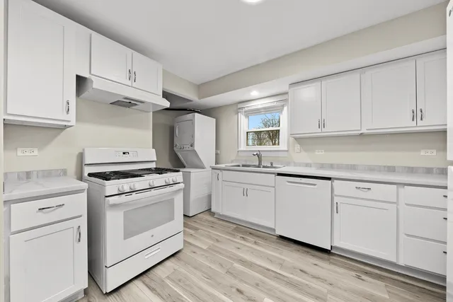 a kitchen with cabinets appliances and wooden floor
