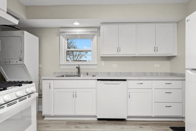 a kitchen with granite countertop white cabinets and a sink
