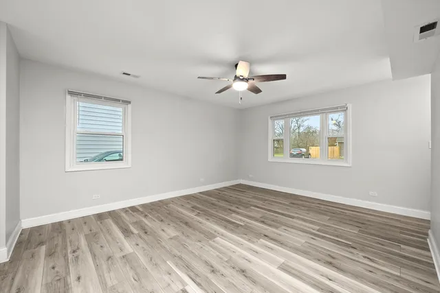 a view of an empty room with a window and a ceiling fan