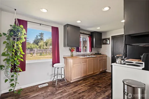 a kitchen that has a lot of cabinets in it and wooden floor