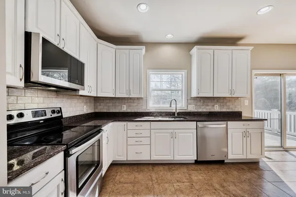 a kitchen with stainless steel appliances a sink a stove a microwave and cabinets