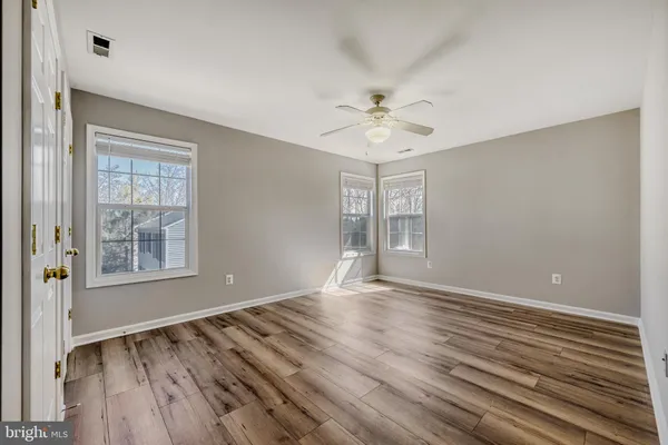 a view of an empty room with a window and a ceiling fan