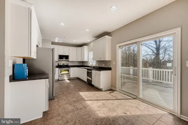 a kitchen with stainless steel appliances kitchen island granite countertop a refrigerator and a sink