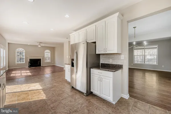 a kitchen with stainless steel appliances a refrigerator a stove a sink cabinets and wooden floor
