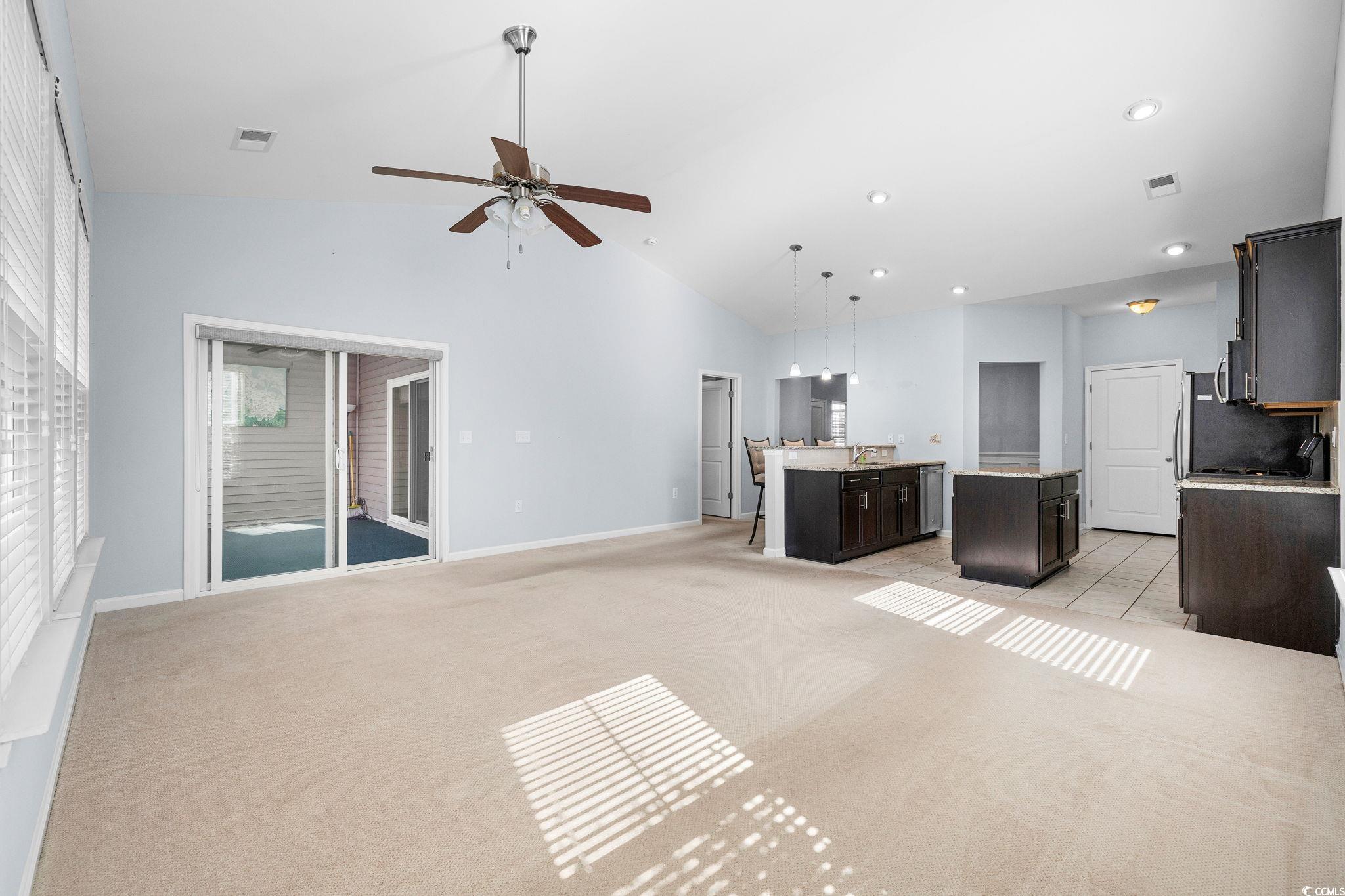 817 Arezzo Way, Unit 1001 Myrtle Beach, SC 29579 - Photo 15 of 40 Unfurnished living room featuring light carpet, a ceiling fan, high vaulted ceiling, and recessed lighting