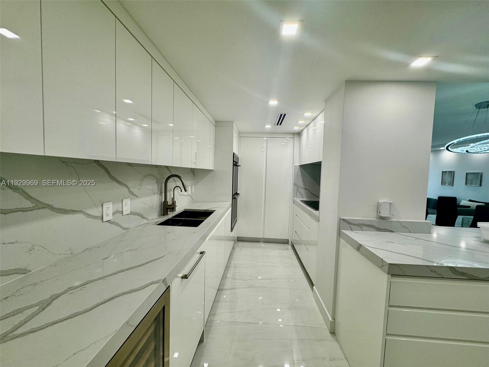 9801 Collins Avenue, Unit 5U Bal Harbour, FL 33154 - Photo 2 of 62 a kitchen with a sink a refrigerator and cabinets