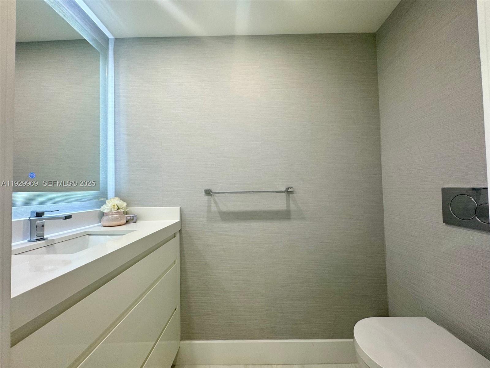 9801 Collins Avenue, Unit 5U Bal Harbour, FL 33154 - Photo 31 of 62 a bathroom with a sink a toilet and mirror