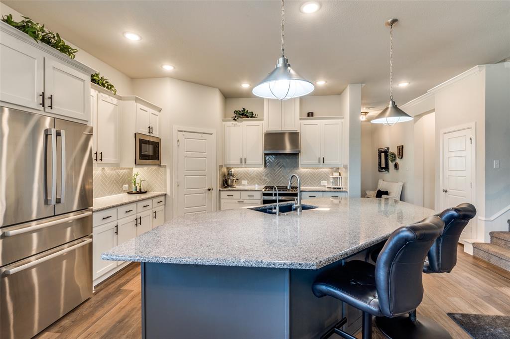 4724 Raspberry Spar Court Arlington, TX 76005 - Photo 9 of 40 a kitchen with stainless steel appliances granite countertop a sink a stove a refrigerator a center island and cabinets