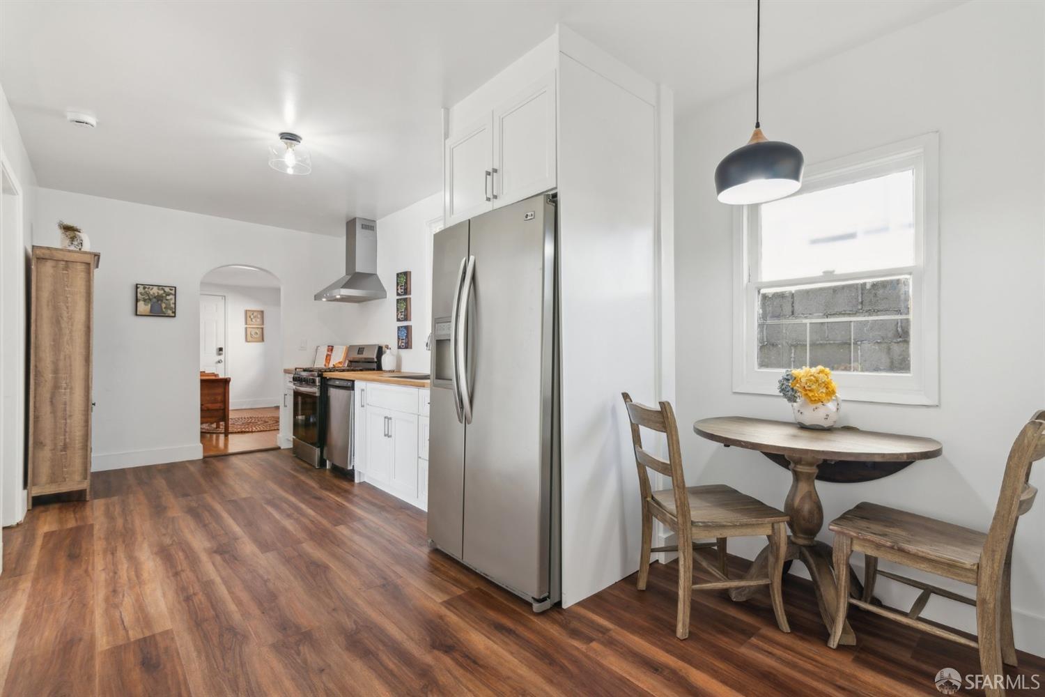 1521 Mitchell Street Oakland, CA 94601 - Photo 9 of 28 a kitchen with stainless steel appliances a dining table chairs refrigerator and sink