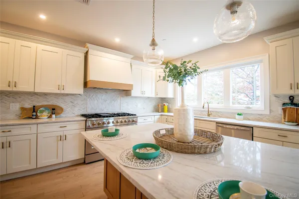 a large kitchen with kitchen island granite countertop a stove a sink a center island and furniture