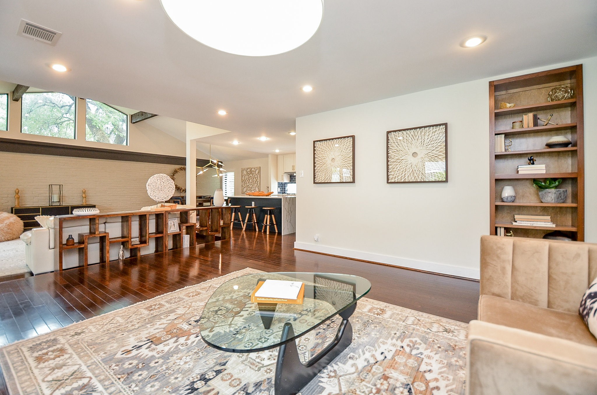 10003 Burgoyne Road Houston, TX 77042 - Photo 48 of 48 An expansive open-concept floorplan unfolds, framed by clerestory windows that draw in soft, natural light throughout the day. Clean architectural lines and built-in shelving create subtle layers of sophistication, while the kitchen’s modern island and pendant lighting anchor the space with contemporary elegance.