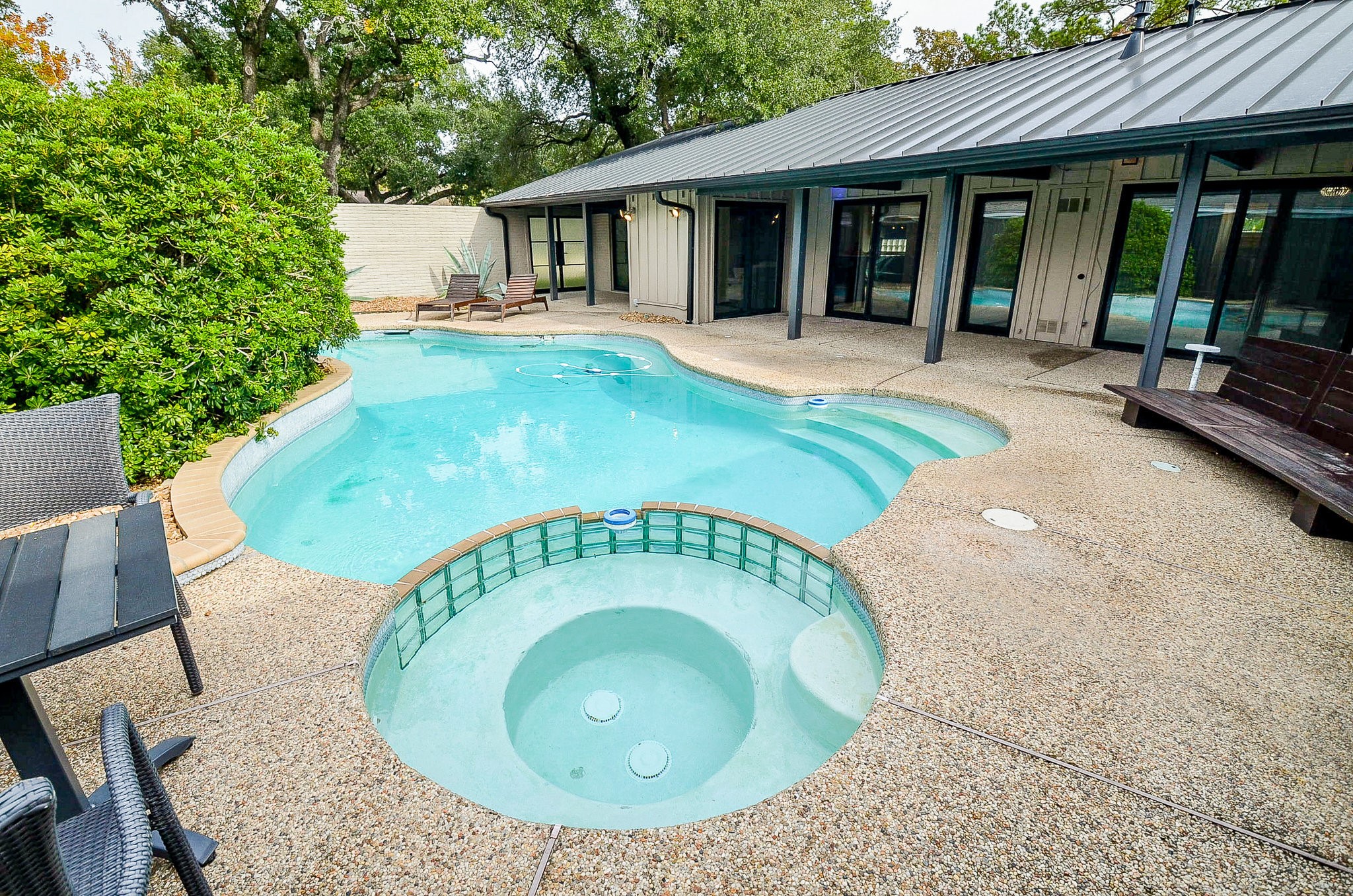 10003 Burgoyne Road Houston, TX 77042 - Photo 38 of 48 Beyond the metal-and-glass double doors, the entrance loggia leads into a welcoming foyer, where glass doors throughout the home reveal serene views of the pool and courtyard