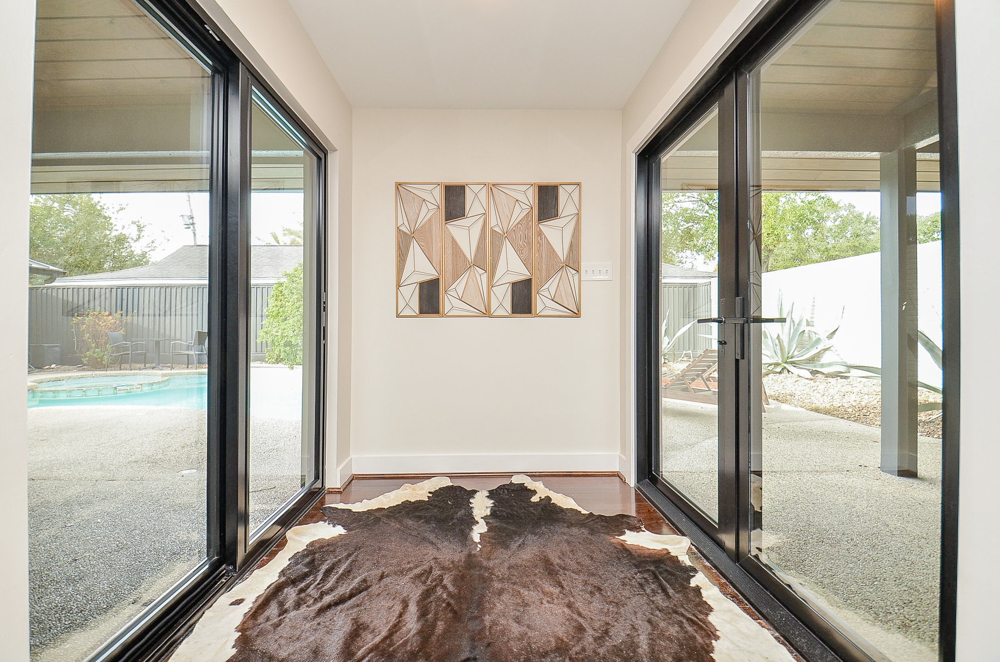 10003 Burgoyne Road Houston, TX 77042 - Photo 9 of 48 After entering through the front double doors, a covered walkway leads through the open courtyard and into the main living spaces, this is the foyer! The living room sits opposite the wall.