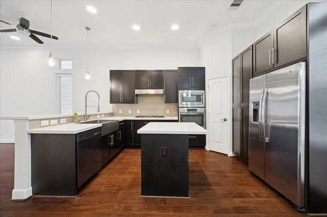a kitchen with a sink refrigerator and cabinets