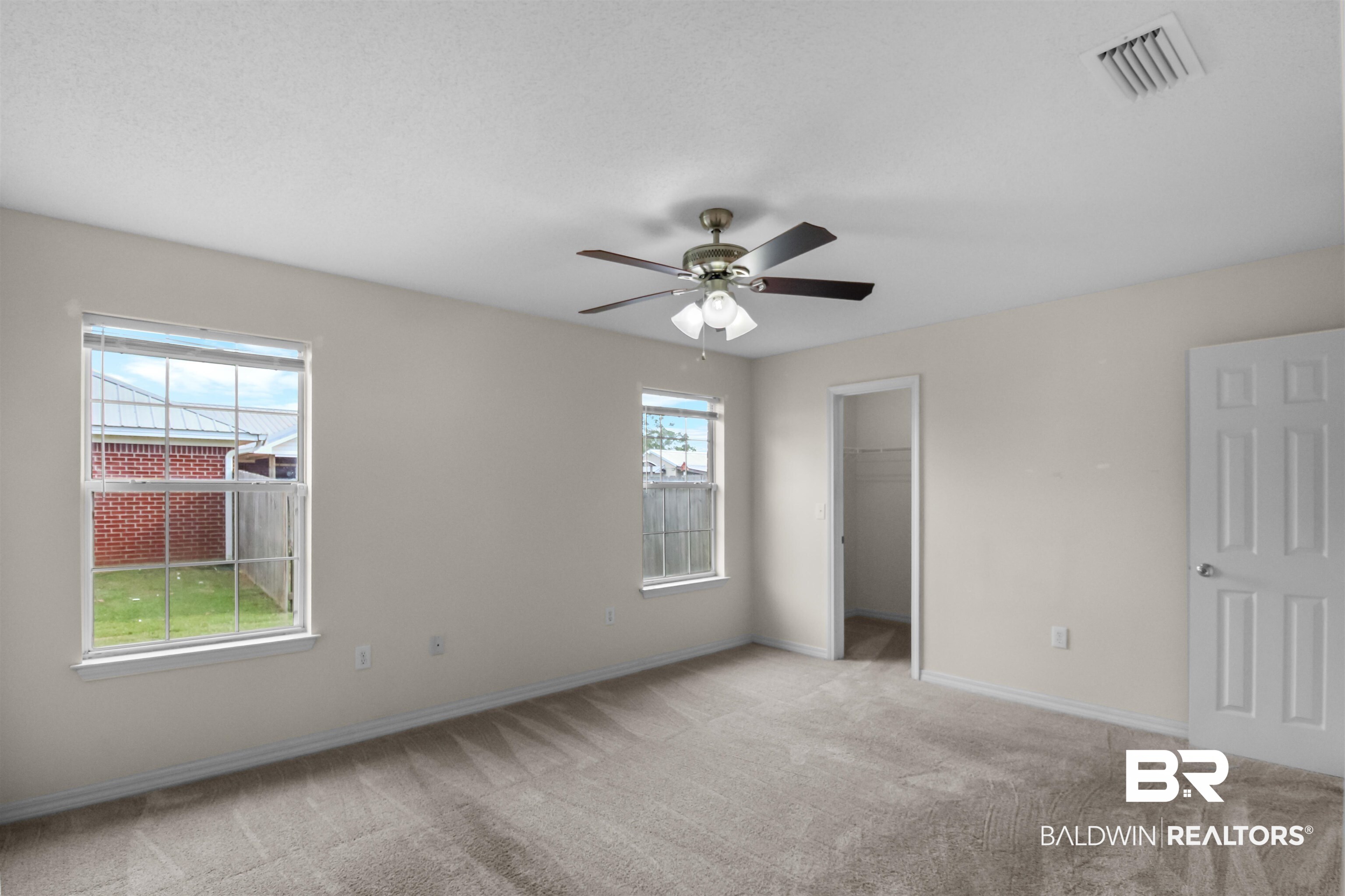 8940 Caitlin Street Foley, AL 36535 - Photo 7 of 27 Primary Unfurnished bedroom featuring a walk in closet, light carpet, and a ceiling fan