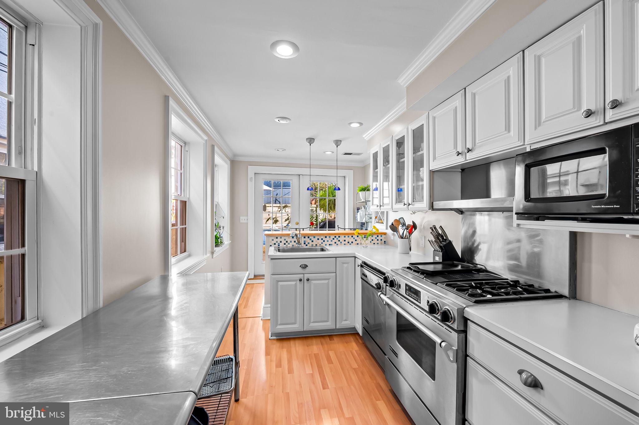 1908 Bank Street Baltimore, MD 21231 - Photo 13 of 37 a kitchen with stainless steel appliances granite countertop a stove top oven a sink dishwasher and a refrigerator with wooden floor