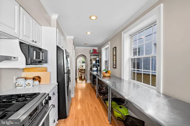 a very nice looking room with wooden floor and cabinets