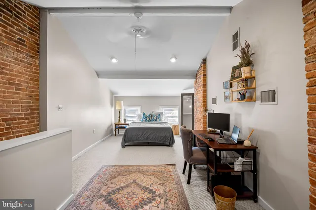 a view of a workspace with furniture and a window