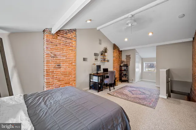 a spacious bedroom with a bed and a chair