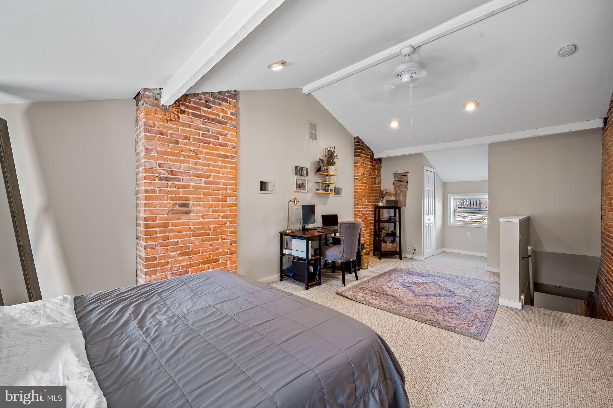 1908 Bank Street Baltimore, MD 21231 - Photo 23 of 37 a spacious bedroom with a bed and a chair