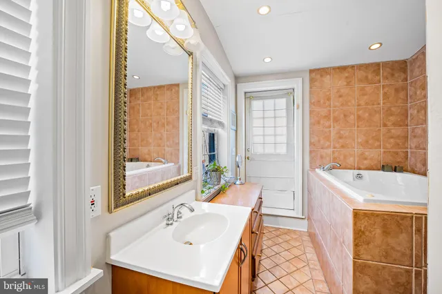 a bathroom with a sink a bathtub and next to a window