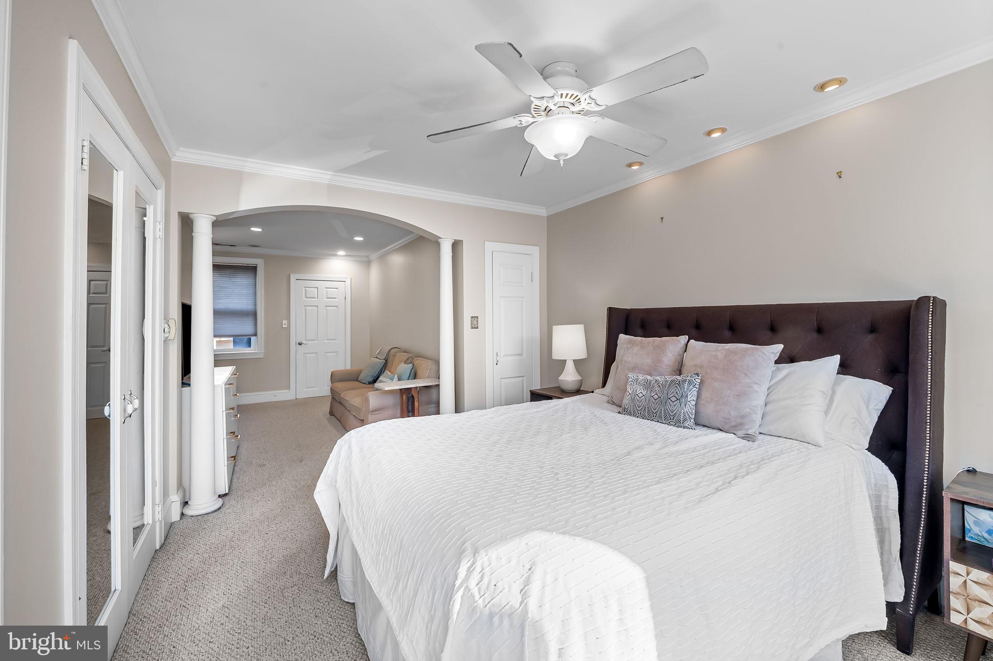 1908 Bank Street Baltimore, MD 21231 - Photo 31 of 37 a spacious bedroom with a bed and a chandelier