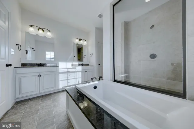 a spacious bathroom with a tub sink and mirror