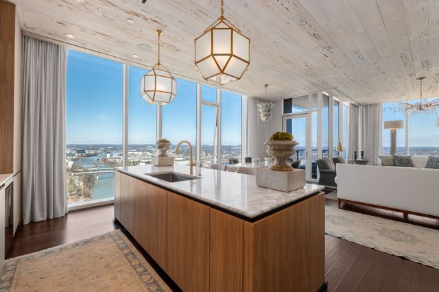 a kitchen with stainless steel appliances granite countertop a sink a stove cabinets and living room view