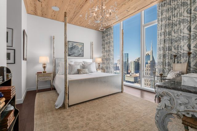 a bedroom with a bed couch and large window