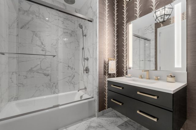 a bathroom with a sink mirror and a shower