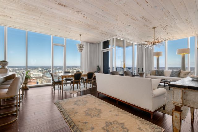 a living room with furniture a flat screen tv and kitchen view