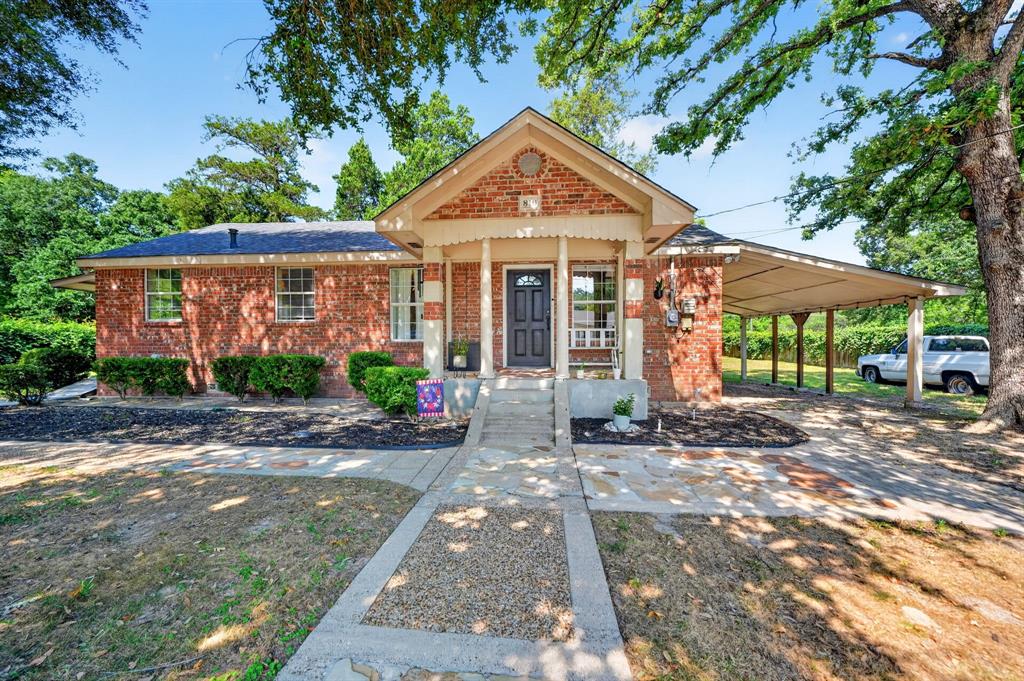 810 Edna Street Athens, TX 75751 - Photo 2 of 28 Brick exterior featuring a covered front porch with white columns, a dark entry door, and multiple windows