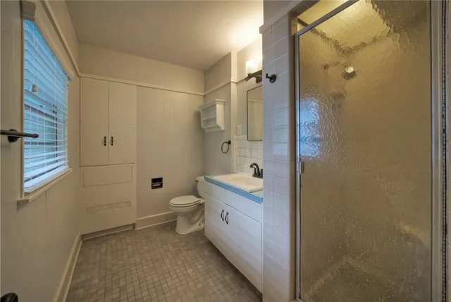 a bathroom with a granite countertop toilet sink and shower
