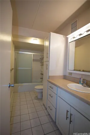 a bathroom with a granite countertop sink a toilet and a mirror