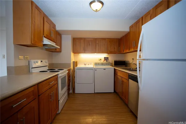 a kitchen with a sink cabinets stainless steel appliances and a window