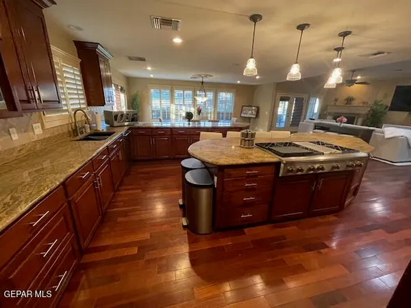a kitchen with stainless steel appliances granite countertop a stove a sink dishwasher and a refrigerator