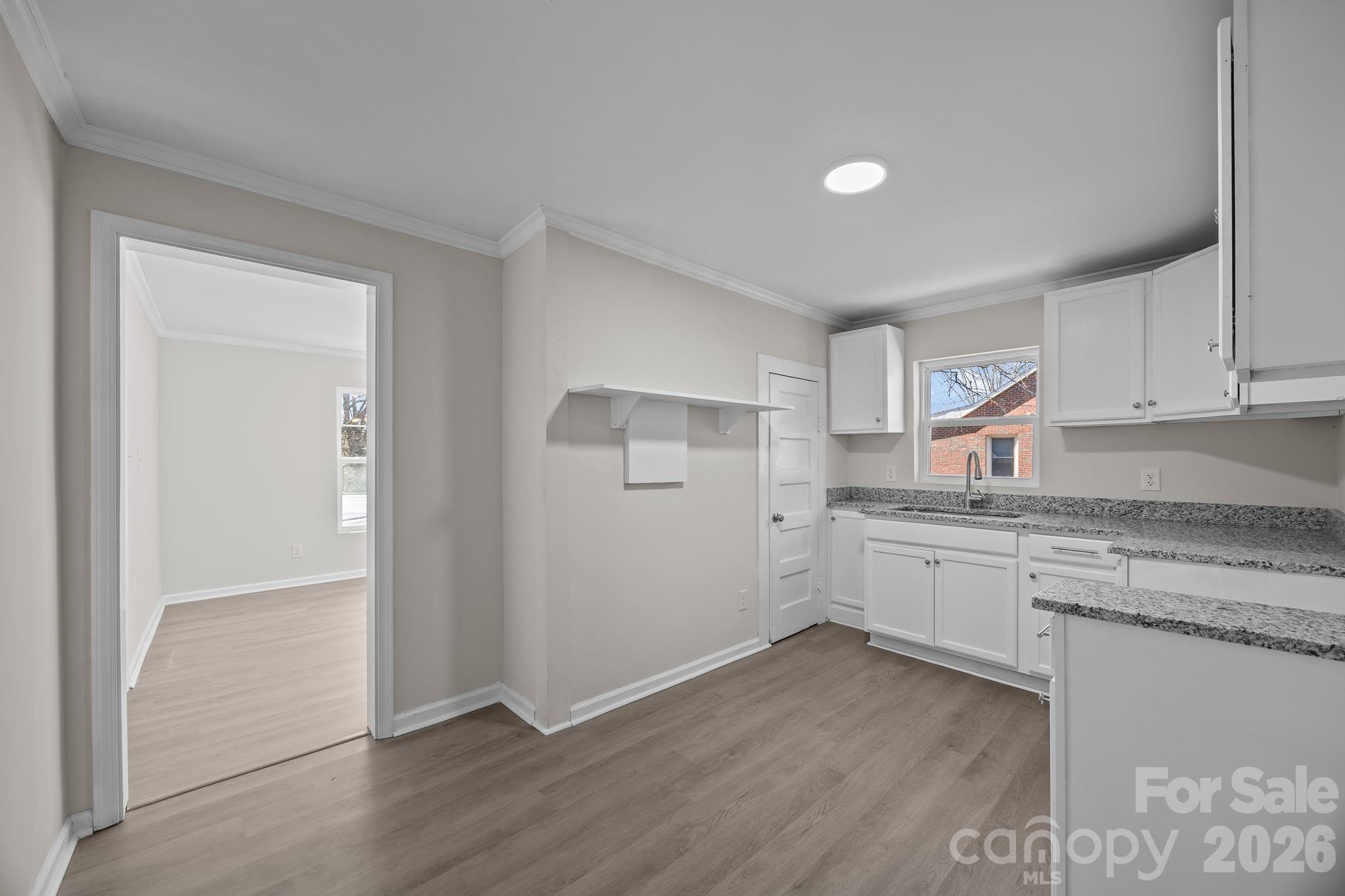 5010 Athens Street Kannapolis, NC 28081 - Photo 19 of 36 a kitchen with granite countertop a sink cabinets and wooden floor