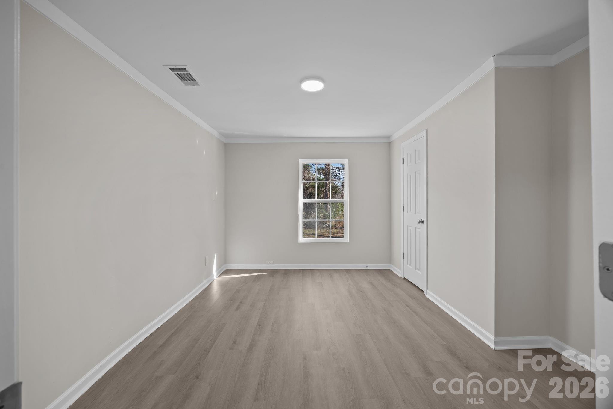 5010 Athens Street Kannapolis, NC 28081 - Photo 24 of 36 a view of an empty room with wooden floor and a window