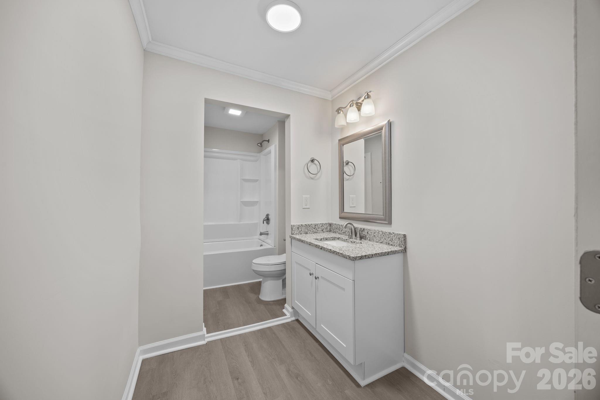 5010 Athens Street Kannapolis, NC 28081 - Photo 27 of 36 a bathroom with a granite countertop sink a toilet and mirror