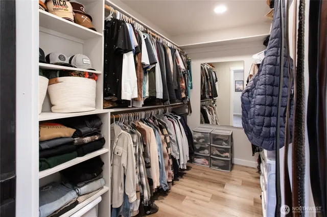 a view of walk in closet with clothes and shoes
